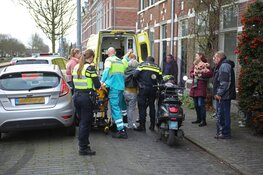 Overstekende vrouw met plant ziet scooterrijdster over het hoofd