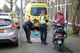 Overstekende vrouw met plant ziet scooterrijdster over het hoofd