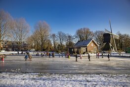 Drukte op het ijs bij de molen aan de Heussensstraat in Haarlem