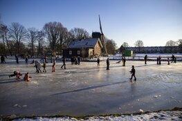 Drukte op het ijs bij de molen aan de Heussensstraat in Haarlem
