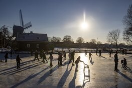 Drukte op het ijs bij de molen aan de Heussensstraat in Haarlem
