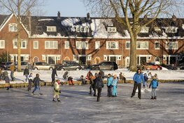 Drukte op het ijs bij de molen aan de Heussensstraat in Haarlem
