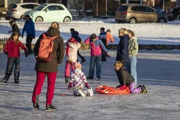 Drukte op het ijs bij de molen aan de Heussensstraat in Haarlem