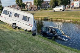 Auto met caravan te water in Velserbroek