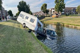 Auto met caravan te water in Velserbroek