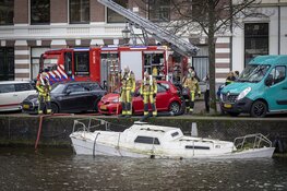 Brandweer pompt deels gezonken boot leeg in centrum Haarlem