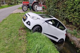 Handrem vergeten, auto rolt sloot in