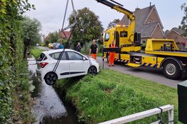 Handrem vergeten, auto rolt sloot in