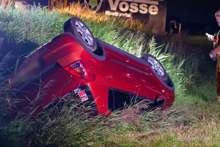 Auto over de kop langs dijk in Beverwijk