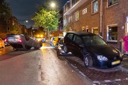 Auto ramt geparkeerd voertuig en vliegt over de kop in Haarlem