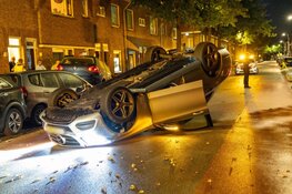 Auto ramt geparkeerd voertuig en vliegt over de kop in Haarlem