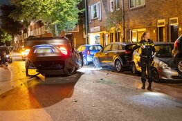 Auto ramt geparkeerd voertuig en vliegt over de kop in Haarlem
