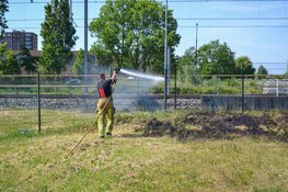 Brandweer blust brandend gras naast spoor Beverwijk